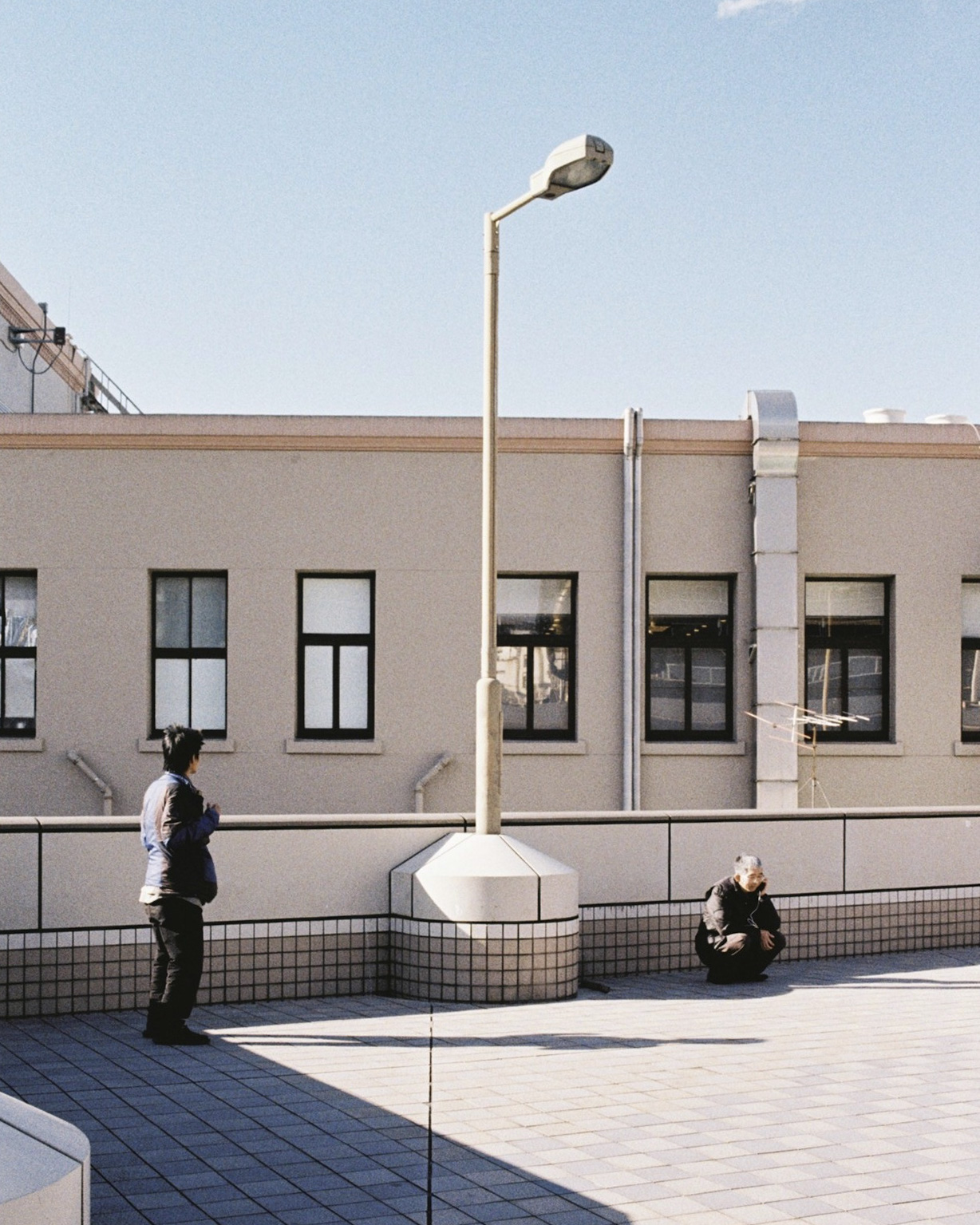Soft urban layers and reflected light on a Japanese street surface.